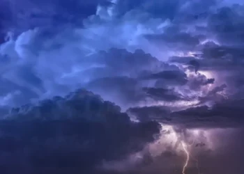 Nuvole temporalesche viola e blu solcate da fulmini nel cielo notturno, foto di repertorio per l’allerta gialla
