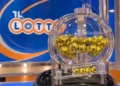 Urna trasparente con palline gialle numerate davanti a un logo del Lotto, in uno studio televisivo di estrazione