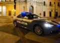 Volante della Polizia di Stato con lampeggianti blu in una piazza di notte, arresto per furto in abitazione a Vittoria