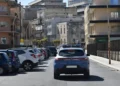Auto della Polizia di Stato in servizio in una strada di Ragusa, tra auto parcheggiate e palazzi del centro