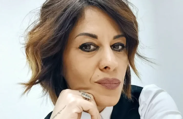 Alessia Russo, autrice de L’Aliena in Azienda, in primo piano con il mento appoggiato sulla mano, su sfondo chiaro