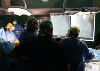 Équipe in sala operatoria al Cannizzaro di Catania osserva sui monitor le immagini dell’angiografo durante un intervento