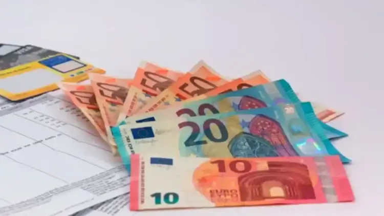 Banconote da 10, 20 e 50 euro a ventaglio accanto a una carta di pagamento e a un modulo, simbolo dell'assegno di inclusione