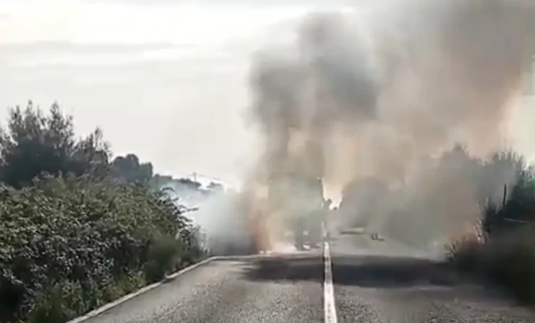 Auto in fiamme sulla strada Cento Pozzi verso Vittoria: fumo grigio denso copre la carreggiata tra la vegetazione
