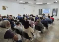 Via pedonale nel centro storico di Ragusa con palazzi in pietra, balconi in ferro, palme, vasi e panchine in legno