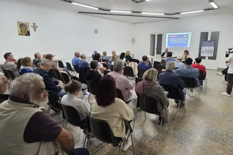 Via pedonale nel centro storico di Ragusa con palazzi in pietra, balconi in ferro, palme, vasi e panchine in legno