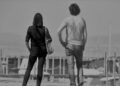 Un uomo e una donna di spalle su una banchina del porto, a qualche passo di distanza: foto simbolica sul bonus affitto