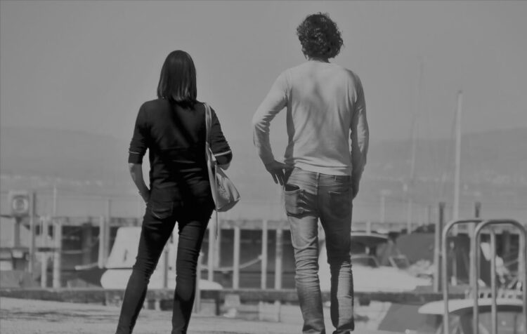 Un uomo e una donna di spalle su una banchina del porto, a qualche passo di distanza: foto simbolica sul bonus affitto