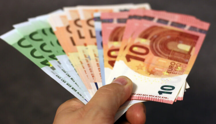 Mano che tiene a ventaglio banconote da 10, 20, 50 e 100 euro, come le somme del bonus Renzi da recuperare col 730