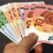 Mano che tiene a ventaglio banconote da 10, 20, 50 e 100 euro, come le somme del bonus Renzi da recuperare col 730