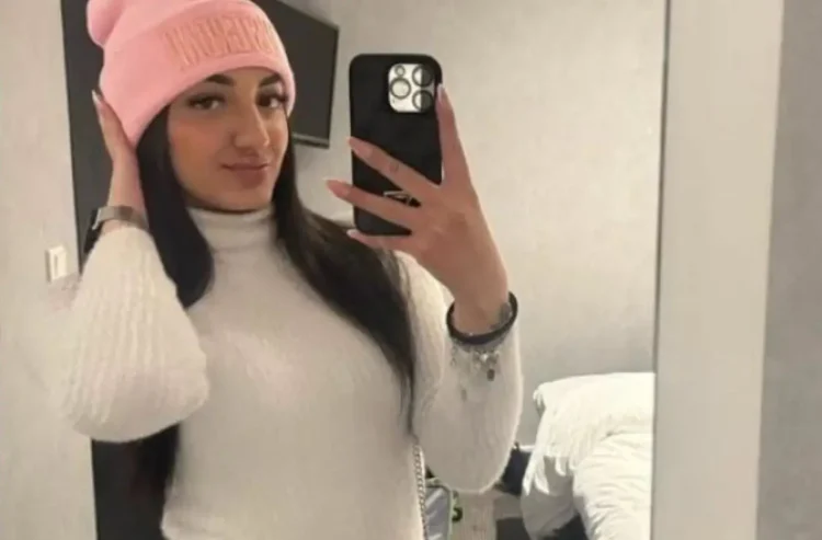 Carola Battaglia, giovane di Vittoria, in un selfie allo specchio con berretto rosa e maglione bianco a collo alto