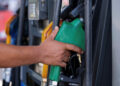 Mano che impugna una pistola erogatrice verde a una pompa di benzina, simbolo del caro carburante denunciato dalla Cgil a Ragusa