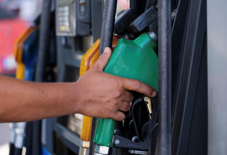 Mano che impugna una pistola erogatrice verde a una pompa di benzina, simbolo del caro carburante denunciato dalla Cgil a Ragusa