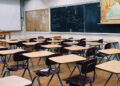 Aula vuota con banchi e un condizionatore a parete, scuole siciliane