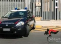 Auto dei carabinieri con lampeggianti blu parcheggiata davanti al cancello di una stazione, con il logo Carabinieri Ragusa