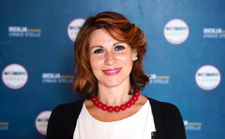 Stefania Campo, deputata regionale M5s, sorride davanti a un pannello blu con i loghi del Movimento 5 Stelle Sicilia