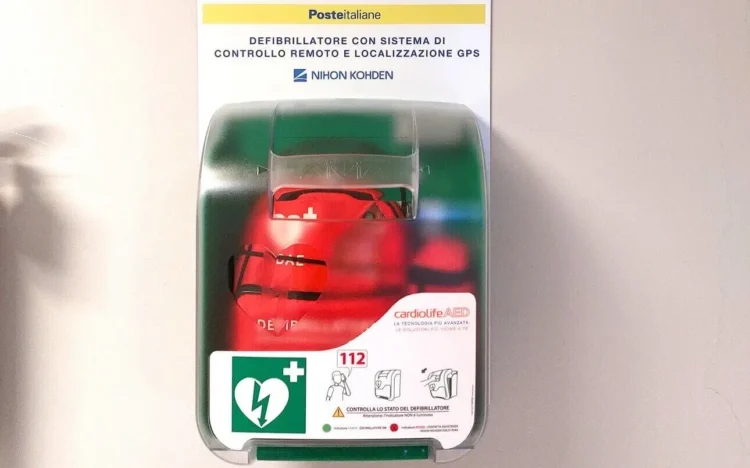 Defibrillatore di Poste Italiane in una teca verde a parete, con sistema di controllo remoto e localizzazione GPS