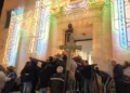Fedeli portano il simulacro di San Francesco fuori dalla chiesa illuminata a festa durante la processione a Ragusa