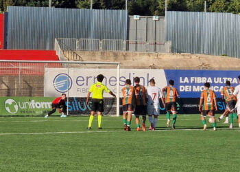 Calcio di rigore in Frigintini Comiso: il portiere in rosso si tuffa, l’arbitro e i giocatori al limite dell’area guardano
