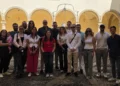 Gruppo di giovani Uici in posa nel chiostro di un edificio storico, con portico ad archi gialli e un pozzo al centro