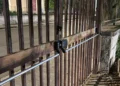 Cancello di un impianto sportivo a Ragusa con maniglione antipanico e lucchetto, affacciato su marciapiede e strada