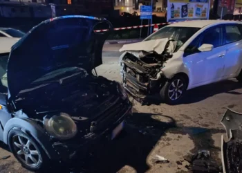Incidente in via Gandhi a Comiso: un'utilitaria scura e una berlina bianca con il frontale distrutto, detriti sull'asfalto