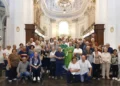 Fedeli in posa con un sacerdote in casula verde davanti all'altare dell'Ecce Homo a Ragusa per la Madonna del Rosario