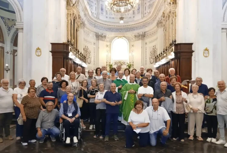 Fedeli in posa con un sacerdote in casula verde davanti all'altare dell'Ecce Homo a Ragusa per la Madonna del Rosario
