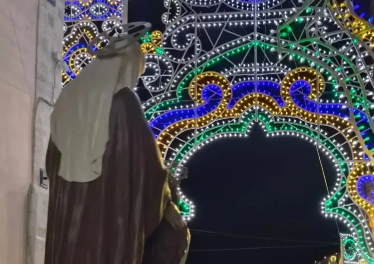 Statua mariana con aureola davanti all'arco di luminarie colorate allestito per la festa a Monterosso Almo