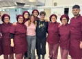 Personale della mensa scolastica in divisa bordeaux posa con due donne nella cucina comunale