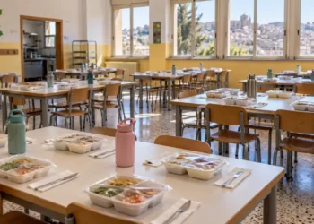 Mensa scolastica a Modica con vaschette di plastica sigillate sui tavoli. Immagine generata con intelligenza artificiale.