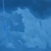 Dipinto di Simone Geraci: nubi bianche e azzurre su un cielo blu scuro, attraversato in verticale da una scia sottile