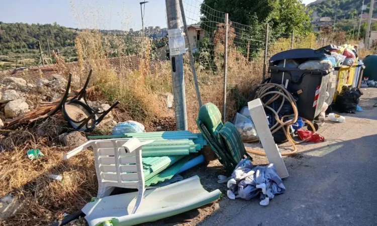 Sedie di plastica, lastre, un tubo e sacchetti di rifiuti abbandonati accanto ai cassonetti a Modica