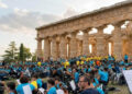 Studenti con le magliette azzurre di Music for Freedom suonano chitarre e fiati davanti alle colonne del tempio di Paestum