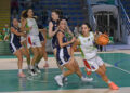 Giocatrice della Passalacqua Ragusa con la maglia numero 9 palleggia in attacco, marcata da avversarie in maglia blu