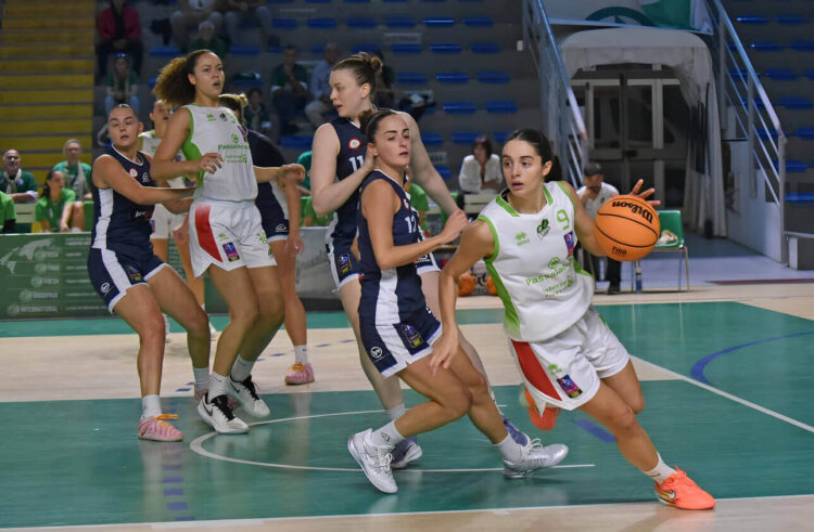 Giocatrice della Passalacqua Ragusa con la maglia numero 9 palleggia in attacco, marcata da avversarie in maglia blu