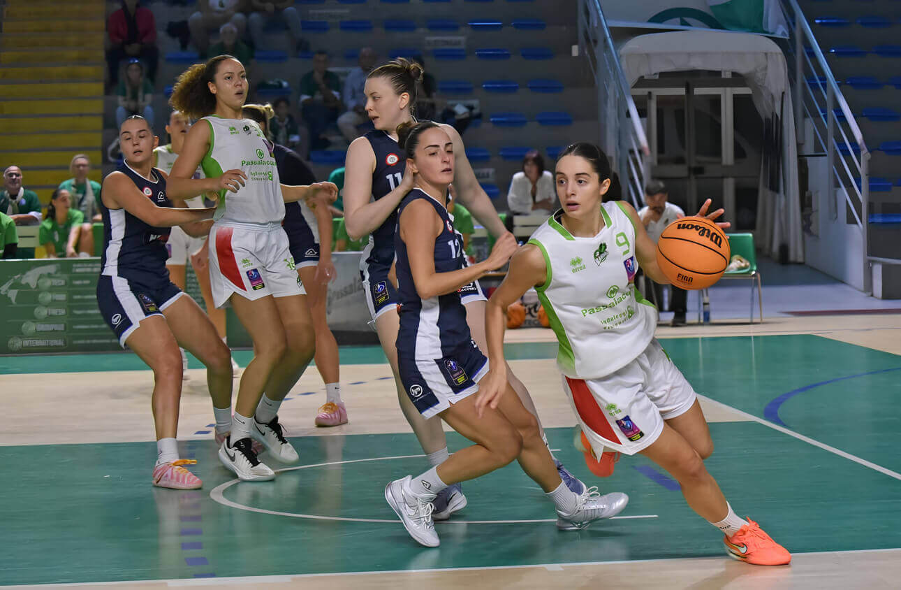 Giocatrice della Passalacqua Ragusa con la maglia numero 9 palleggia in attacco, marcata da avversarie in maglia blu