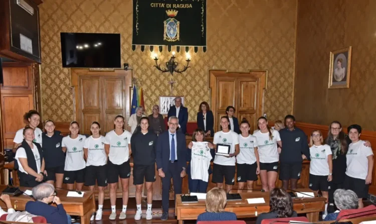 Le giocatrici della Passalacqua Ragusa premiata posano con la targa e una maglia nell'aula consiliare del Comune di Ragusa