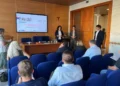 Sala riunioni con lo schermo di Plan4COLD su Ragusa, Modica e Vittoria, tre relatori in piedi e il pubblico seduto