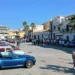 Auto d'epoca parcheggiate in piazza Sorelle Arduino a Scoglitti, tra palme e visitatori, con una cabrio blu in primo piano