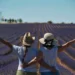 Due donne di spalle con cappello di paglia, abbracciate e a braccia aperte in un campo di lavanda: simbolo del reddito di libertà