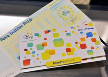 Un Buono fruttifero postale cartaceo e un Libretto Smart di risparmio postale appoggiati su un piano grigio