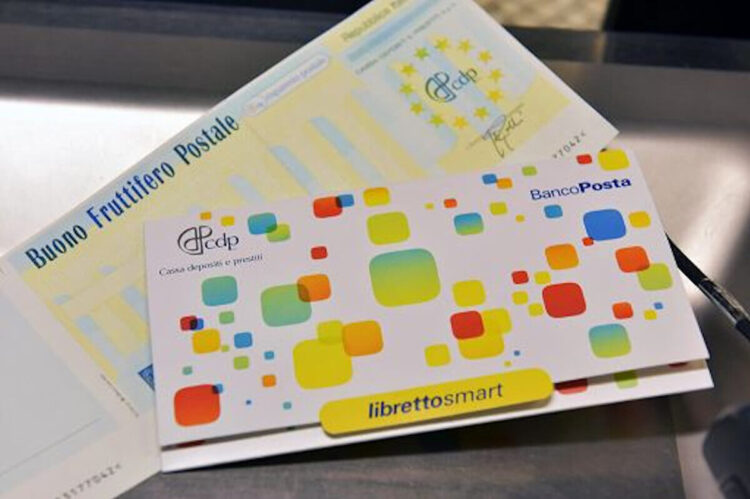 Un Buono fruttifero postale cartaceo e un Libretto Smart di risparmio postale appoggiati su un piano grigio