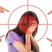 Ragazza con il volto coperto dalle mani dentro un mirino rosso, indicata da quattro dita: lo stigma sulla salute mentale