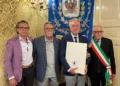 Salvatore Tolaro con la pergamena Vittoria Insigne accanto al sindaco con la fascia tricolore, davanti al gonfalone