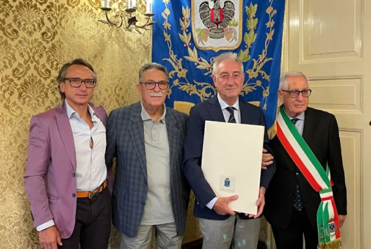 Salvatore Tolaro con la pergamena Vittoria Insigne accanto al sindaco con la fascia tricolore, davanti al gonfalone