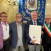 Salvatore Tolaro con la pergamena Vittoria Insigne accanto al sindaco con la fascia tricolore, davanti al gonfalone