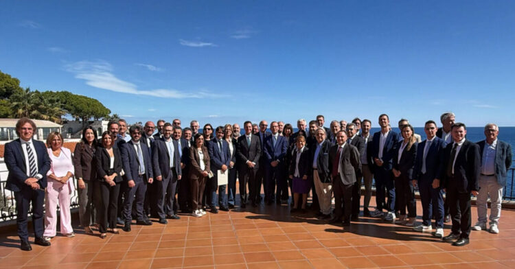 Foto di gruppo dei sindaci di Forza Italia in Sicilia su una terrazza ad Aci Castello, con il mare alle spalle