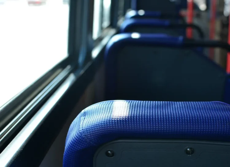 Fila di sedili blu vuoti dentro un autobus di linea, il tipo di mezzo usato dagli studenti pendolari per andare a scuola