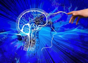 Disegno stilizzato di testa e cervello umano in profilo su sfondo blu, con una mano che emette un impulso luminoso verso il cervello